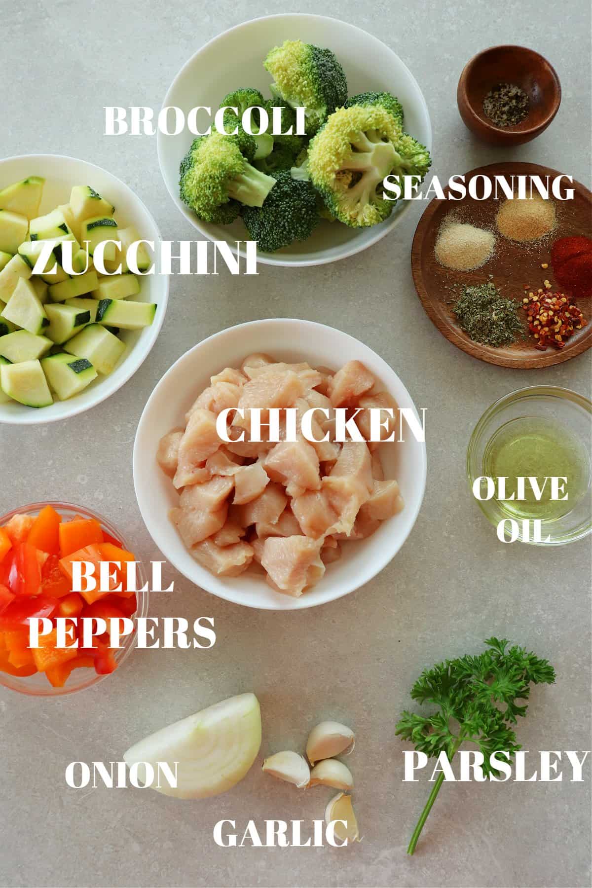 Ingredients for air fryer chicken and vegetables on a gray board.