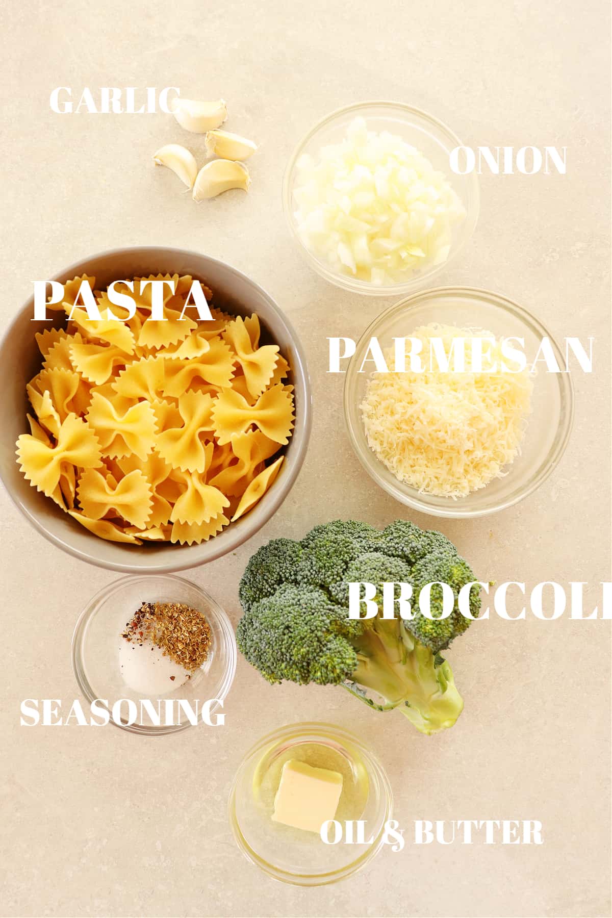 Ingredients for broccoli pasta on a gray board.