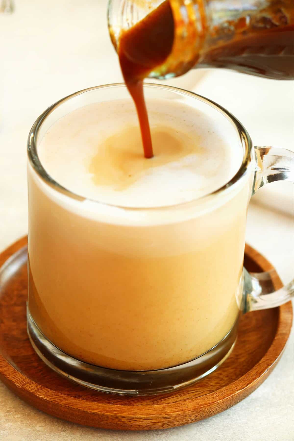 Pumpkin syrup poured into a glass mug with coffee.