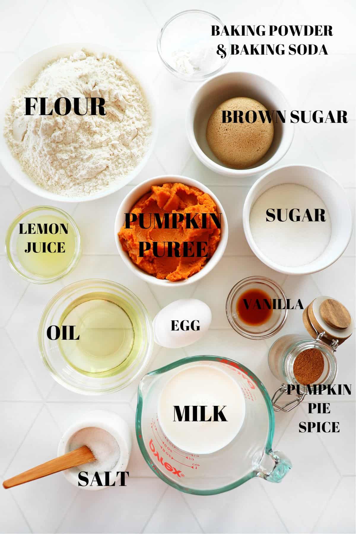 Ingredients for pumpkin muffins on a white tile board.