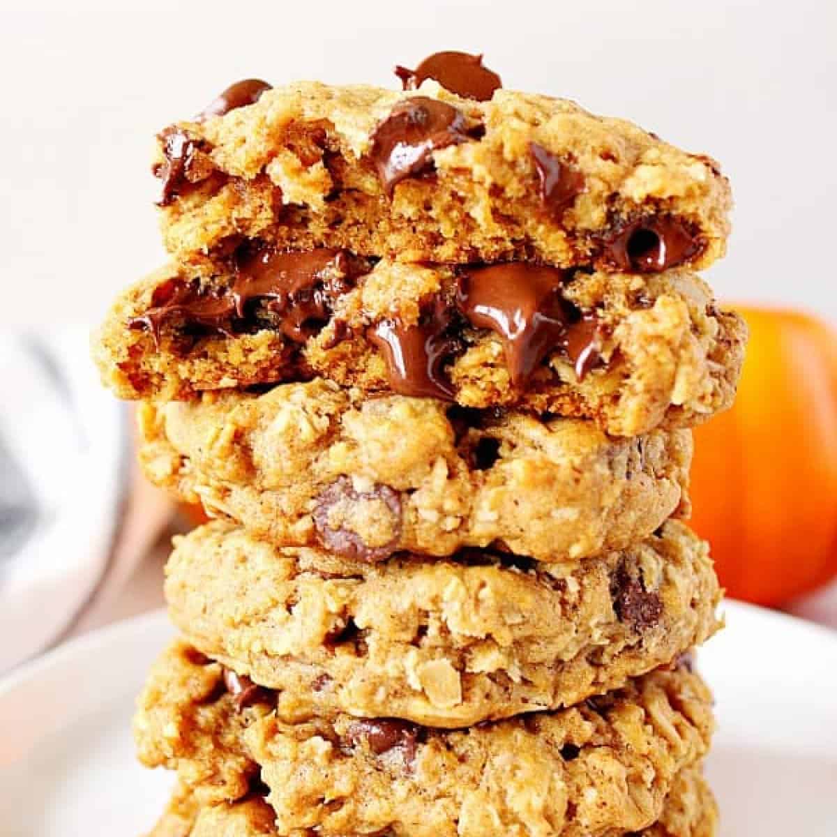Square photo of pumpkin oatmeal cookies stacked on a white plate.