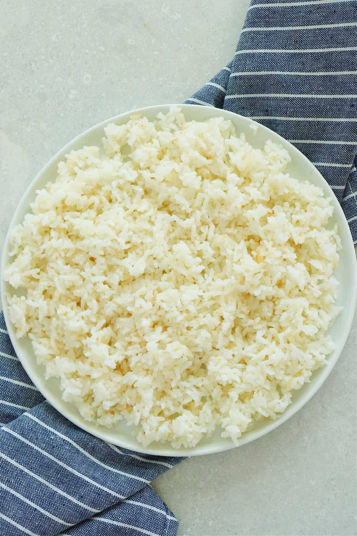 Cooked white rice on a white plate.