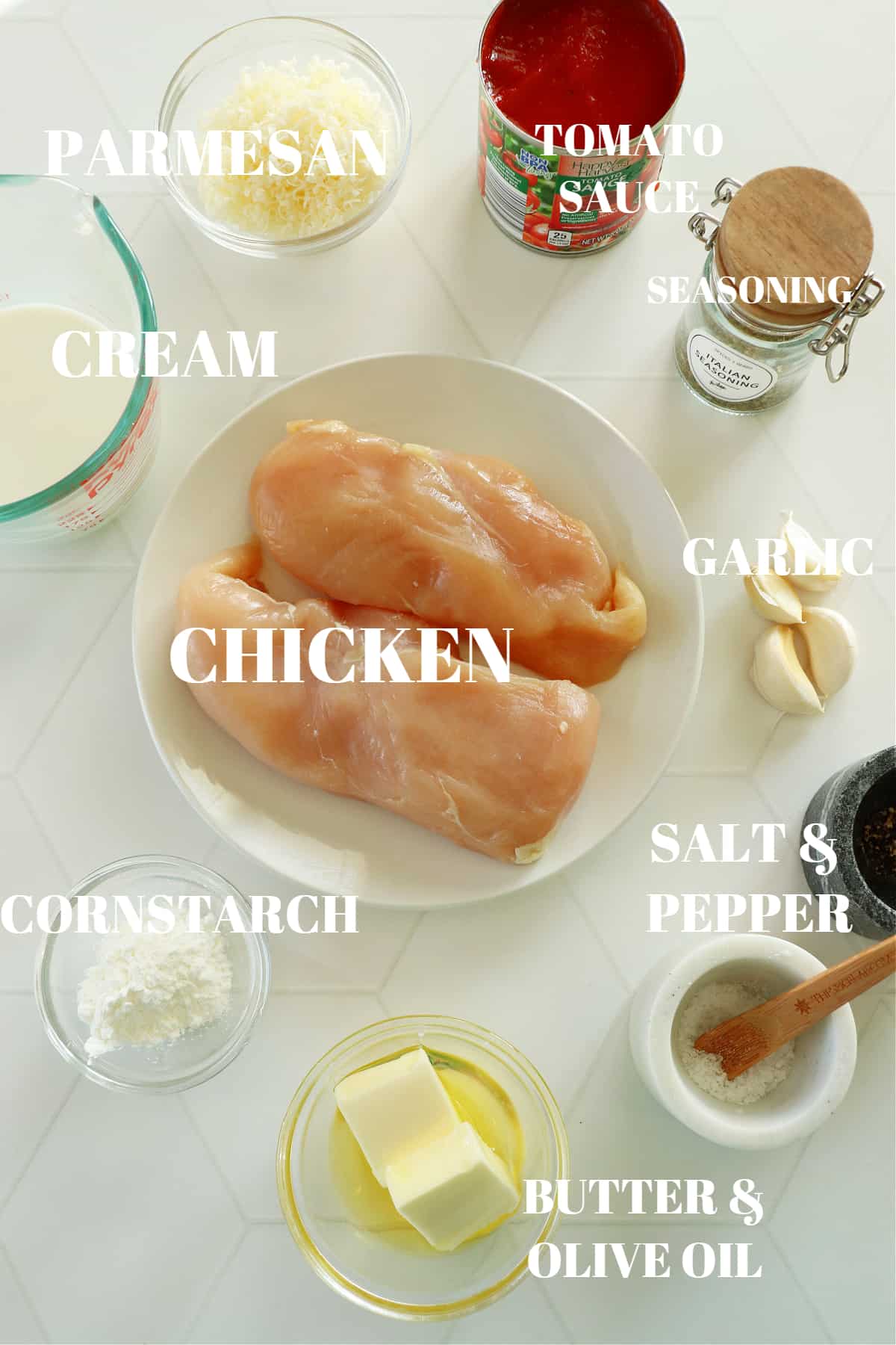 Ingredients for creamy tomato chicken skillet on a white board.