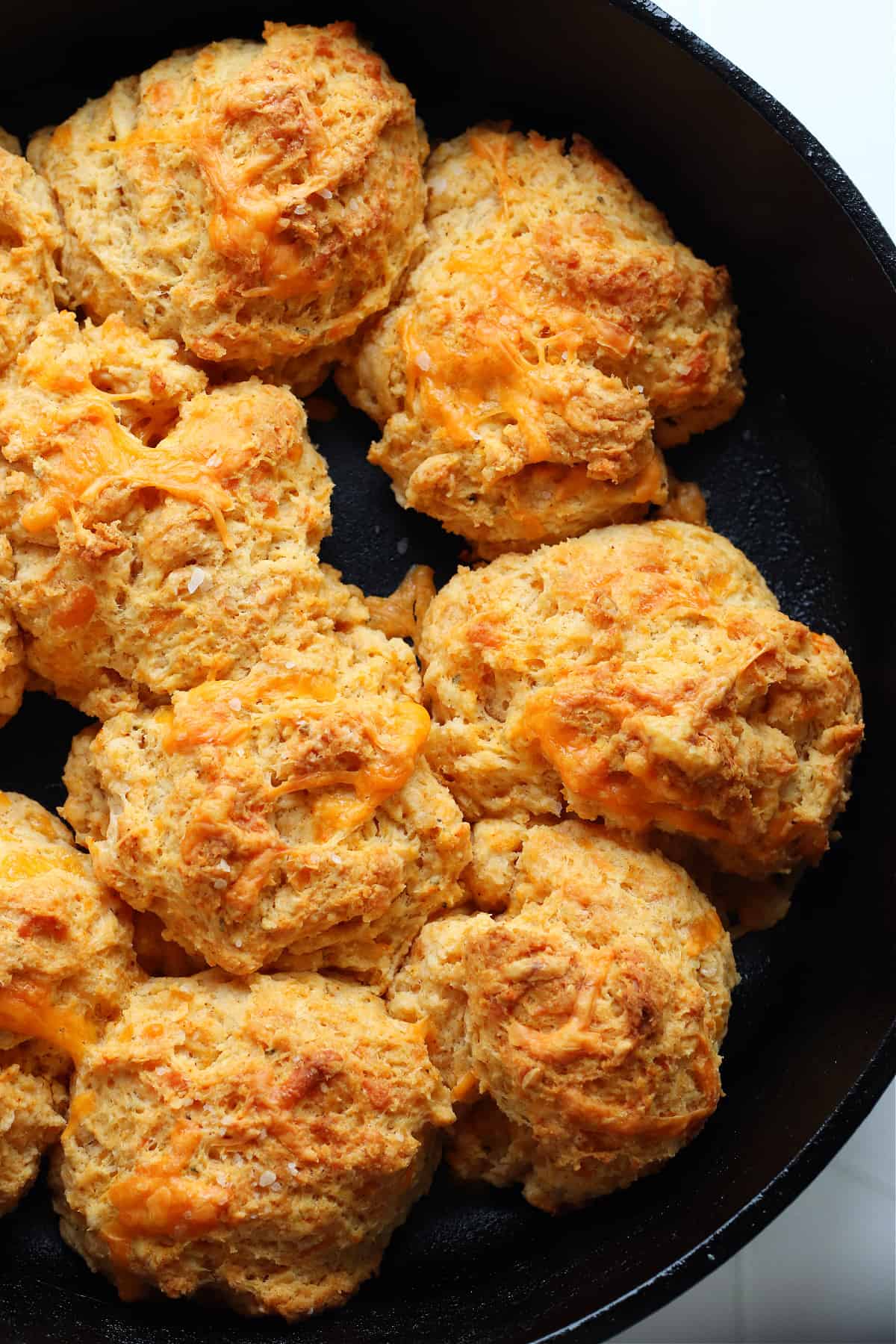Close up of biscuits in a cast iron skillet.