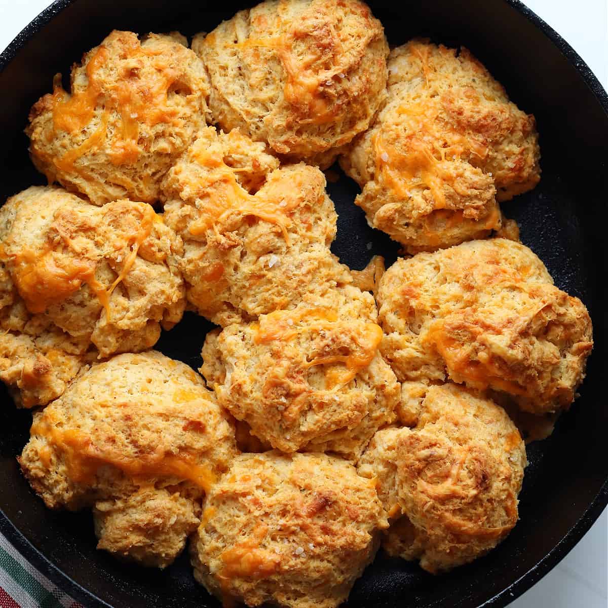 Square image of skillet biscuits in a cast iron skillet.
