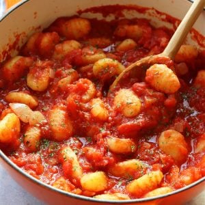 Square image of gnocchi with tomato sauce in a Dutch oven.