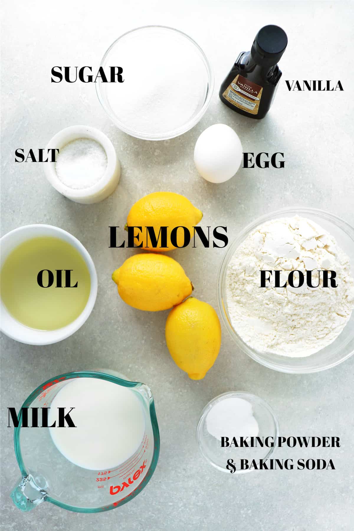All ingredients for lemon cake on a gray board.