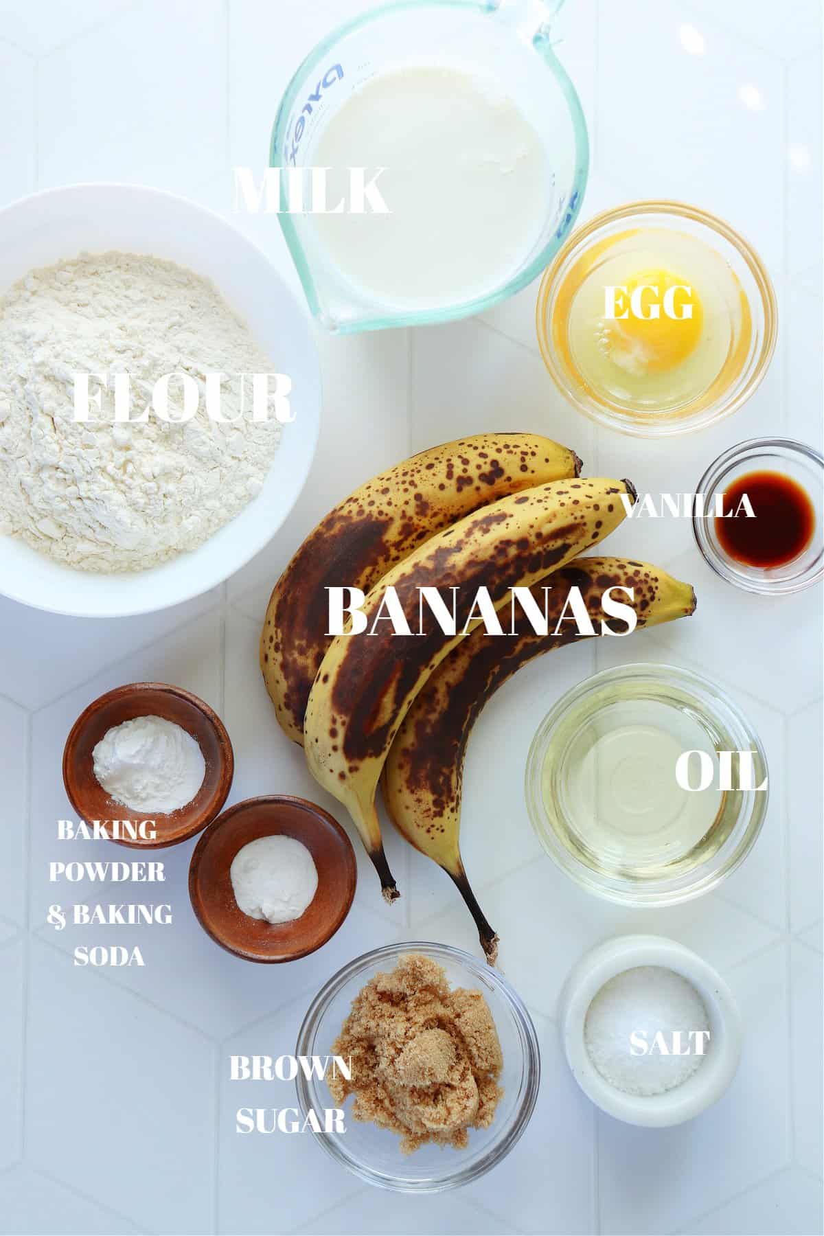 All ingredients for banana pancakes on a white tile board.