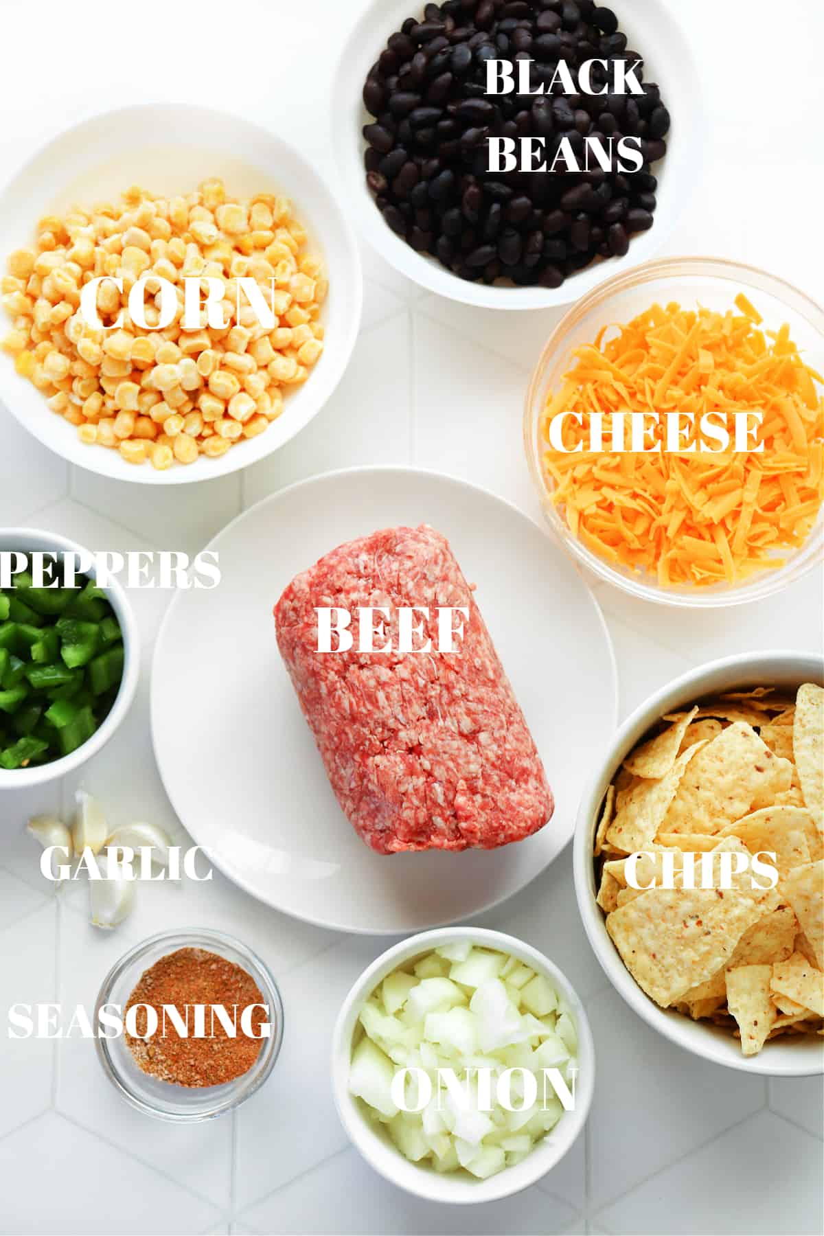 All ingredients for taco casserole on a white tile board.